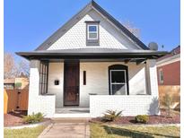 Charming bungalow with white brick and unique scale siding detail under the eaves at 3120 N Race St, Denver, CO 80205