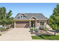 Charming home featuring a well-manicured lawn, stone accents, and a two-car garage with a large driveway at 19753 E 54Th Ave, Denver, CO 80249