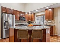 This beautiful kitchen features dark wood cabinets, granite countertops, and stainless steel appliances at 16278 E 105Th Way, Commerce City, CO 80022