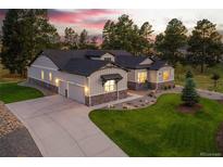 Stunning home with a three-car garage, beautiful landscaping, and a long driveway at 9228 Lone Timber Ct, Parker, CO 80134