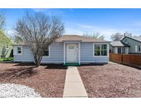 Charming home featuring light blue siding and a well-manicured front yard with mature trees at 1740 Trenton St, Denver, CO 80220