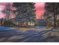 Brick ranch home with gray garage door and mature landscaping at 7076 S Newland St, Littleton, CO 80128