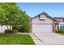 Charming home with a two-car garage, fresh lawn, mature tree, and lovely front yard landscaping at 2247 S Lima Ct, Aurora, CO 80014
