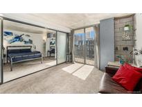 Bright bedroom featuring sliding glass doors, exposed ductwork, and concrete ceilings at 1020 15Th St # 17K, Denver, CO 80202