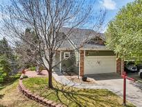 Charming home with stone accents, a two-car garage, manicured lawn, and walkway to the front door at 6701 W Yale Ave, Lakewood, CO 80227