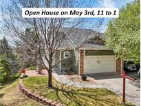 Charming home with a two-car garage, manicured lawn, and inviting brick-paved patio at 6701 W Yale Ave, Lakewood, CO 80227