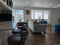 Bright living area features hard floors, plenty of windows, and comfortable furniture at 9133 W Cedar Dr # A, Lakewood, CO 80226