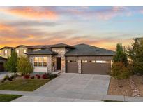 Inviting single-story home featuring a stone facade, well-manicured lawn, and a spacious three-car garage at 7814 S Grand Baker Ct, Aurora, CO 80016