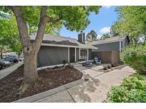 Charming home featuring mature trees and a cozy front patio seating area, perfect for relaxing outdoors at 10177 E Peakview Ave, Englewood, CO 80111