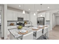Bright kitchen with granite countertops, stainless steel appliances, and barstool seating at 24447 E Ada Ave, Aurora, CO 80018