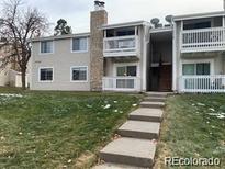 Traditional-style condo building with an exterior balcony and landscaped yard at 14493 E Jewell Ave # 102, Aurora, CO 80012