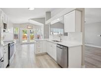 Bright kitchen featuring white cabinetry, stainless steel appliances, and hardwood floors at 765 Freestone St, Brighton, CO 80603