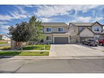 Charming two-story home boasts a well-maintained lawn, a spacious driveway, and an attached two-car garage at 4996 Cathay Ct, Denver, CO 80249