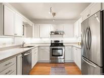 Well-lit kitchen featuring stainless steel appliances, white cabinets, and granite countertops at 695 S Alton Way # 9C, Denver, CO 80247