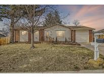 Charming single-story home with a well-manicured front yard and attached garage at 6233 W 75Th Ave, Arvada, CO 80003
