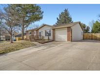 Charming single-story home with a cozy front porch, attached garage and spacious driveway at 6233 W 75Th Ave, Arvada, CO 80003
