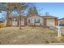 Charming single-story home featuring brick accents, a front deck, and an attached garage at 6233 W 75Th Ave, Arvada, CO 80003
