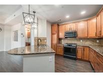 Beautiful kitchen with granite countertops, wood floors, updated cabinets, and stainless steel appliances at 7865 Vallagio Ln # 308, Englewood, CO 80112