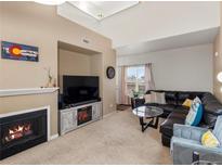Comfortable living room featuring a fireplace, TV, and a large sectional couch for ample seating at 5800 Tower Rd # 610, Denver, CO 80249