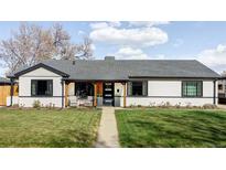 Charming single-story home features a well-manicured lawn and cozy covered porch seating area at 1248 Ursula St, Aurora, CO 80011
