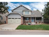 Charming two-story home with a well-maintained front yard and a two car attached garage at 49 Dawn Heath Cir, Littleton, CO 80127