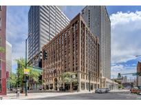 Brick building exterior at the corner of a city street with modern buildings in the background at 444 17Th St # 304, Denver, CO 80202