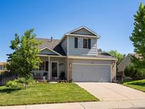 Charming two-story home featuring a well-manicured lawn and inviting front porch at 21351 E Williamette Pl, Centennial, CO 80015