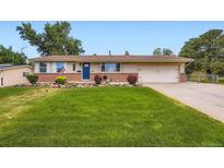 Charming ranch-style home with manicured lawn, brick accents, and a two-car garage at 4244 W Monmouth Ave, Littleton, CO 80123
