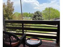 Relaxing balcony featuring a bistro set with views of green trees and distant landscaping at 539 Wright St # 203, Lakewood, CO 80228