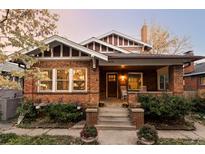 Brick home with inviting front porch and well-manicured landscaping at 626 Fillmore St, Denver, CO 80206