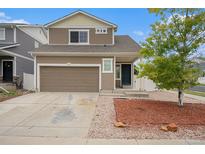 Charming two-story home featuring a well-kept lawn, attached garage, and inviting front entrance at 5550 Malta St, Denver, CO 80249