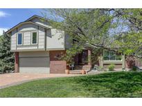 Charming two-story home with brick and siding exterior, manicured lawn, and mature trees at 7877 W 110Th Dr, Westminster, CO 80021