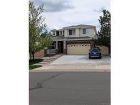 Charming two-story home featuring a brick facade, two-car garage, and inviting front porch at 20928 E Hamilton Ave, Aurora, CO 80013