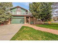Charming home featuring a two-car garage, second story balcony, and a brick-lined walkway at 7655 S Olive Cir, Centennial, CO 80112