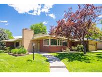 Charming brick home featuring a well-manicured lawn, mature trees, and a welcoming walkway at 6600 E 4Th Ave, Denver, CO 80220