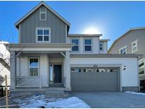 Charming two-story home with a two-car garage, stylish gray and white color scheme, and inviting front porch at 5546 Inland Ave, Firestone, CO 80504