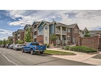 Attractive condo building featuring balconies, a mix of siding, brick exterior, and well-maintained landscaping at 2705 S Danube Way # 110, Aurora, CO 80013