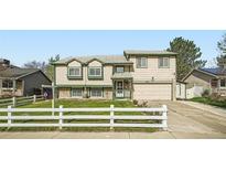 Two-story home featuring well-maintained landscaping and a white picket fence at 5987 S Pierson St, Littleton, CO 80127