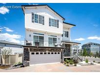 A charming two-story home boasting a white exterior, stone accents, and a paved driveway under a bright blue sky at 4443 N Quatar Ct, Aurora, CO 80019