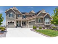 Charming two-story home with a three-car garage, stone accents and a well-manicured lawn at 8761 S Wenatchee Ct, Aurora, CO 80016