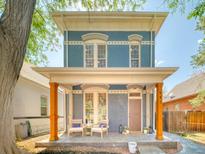 Charming two-story home with a covered front porch and vibrant blue brick exterior at 541 Fox St, Denver, CO 80204