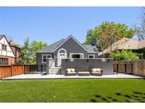 Charming gray home featuring an outdoor living space with seating and an expansive artificial lawn at 420 N Colorado Blvd, Denver, CO 80206