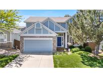 Charming exterior of a well-maintained two-story home with blue accents, stone details and a manicured front yard at 3102 White Oak Trl, Highlands Ranch, CO 80129