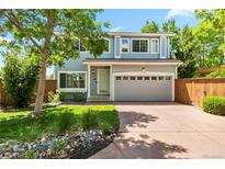 Charming two-story home with a two-car garage, manicured lawn and mature trees at 1526 Braewood Ave, Littleton, CO 80129