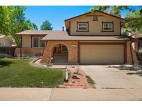 Charming two-story home featuring a brick facade, mature trees, and a spacious two-car garage at 4617 S Norfolk Way, Aurora, CO 80015