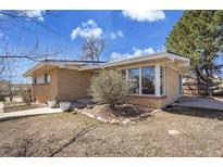 Charming brick home featuring a sunroom and well-manicured landscaping at 8005 Emerald Ln, Broomfield, CO 80020