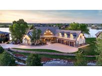 Stunning waterfront home features a large circular driveway, mature landscaping, and a four-car garage at 9833 Shoreline Dr, Longmont, CO 80504