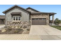 Charming home exterior with stone accents, a two-car garage, and a well-maintained front yard at 3477 New Haven Cir, Castle Rock, CO 80109