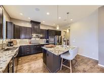 Modern kitchen features dark cabinetry, stainless steel appliances, and a large island with granite countertop at 3477 New Haven Cir, Castle Rock, CO 80109