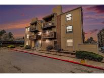 Inviting condo with brick accents and multiple balconies, set against a vibrant sunset sky at 15350 E Arizona Ave # 106, Aurora, CO 80017